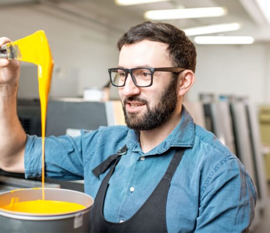 Cómo hacer una fábrica de pinturas | Qué necesitas y 5 tips para hacerlo Hombre viendo su producto luego de saber cómo hacer una fábrica de pinturas