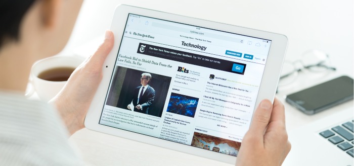 Persona leyendo el periódico The New York Timesa través de su iPad.
