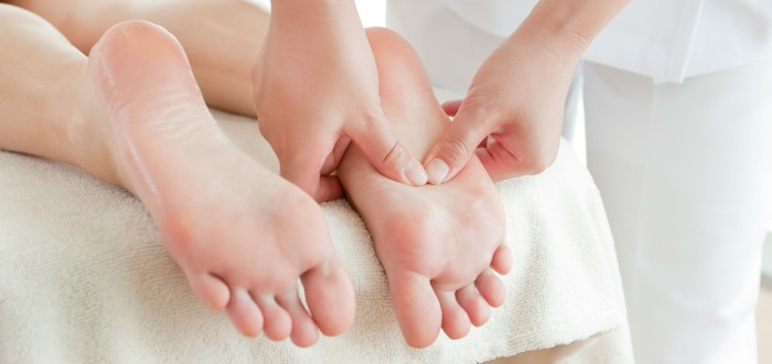 Persona recibiendo un masaje en una sesión de reflexología, terapia alternativa para mejorar la salud