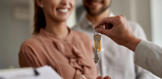 Elección del local de negocio | ¿Cómo encontrarlo? ¿Alquilar o comprar? Mujer recibiendo las llaves del local para su negocio