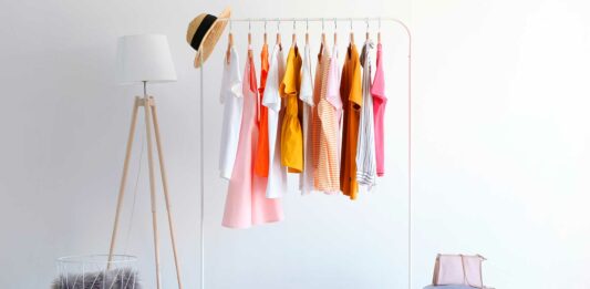 Cómo iniciar un negocio de ropa | Pasos para emprender en el mercado textil ropa colgada expuesta en un cuarto
