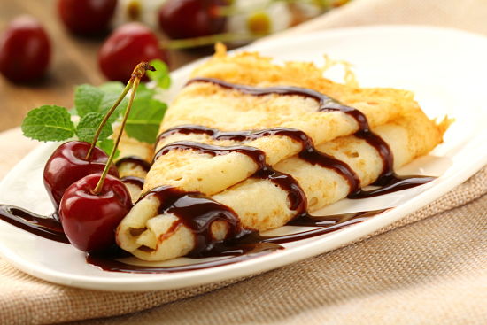Sweet pancake with chocolate sauce and cherries