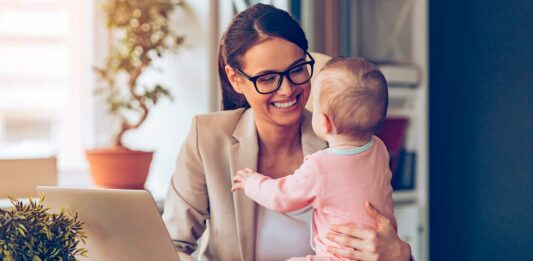 13 ideas de negocios desde casa para madres solteras | ¡Comienza a ganar dinero YA! mujer con su bebé sentada frente al computador