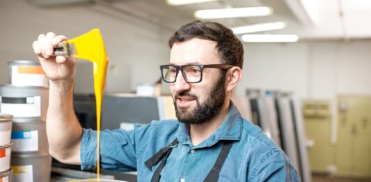 Cómo hacer una fábrica de pinturas | Qué necesitas y 5 tips para hacerlo Hombre viendo su producto luego de saber cómo hacer una fábrica de pinturas