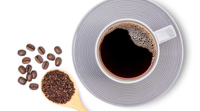 7 mejores franquicias de café | Súmate al negocio de las cafeterías con energía taza de café con cuchara llena de granos de café