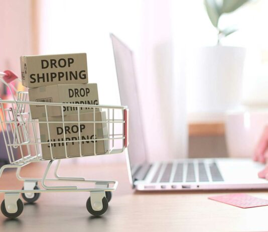 Tienda online dropshipping | Un negocio de poca inversión carritos de compra en minuatura junto a una laptop llenos de cajas con la leyenda "dropshipping"