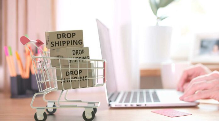 Tienda online dropshipping | Un negocio de poca inversión carritos de compra en minuatura junto a una laptop llenos de cajas con la leyenda "dropshipping"