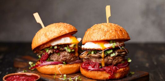 7 mejores franquicias de hamburguesas 2020 | Invierte en lo más vendido del «fast food» Dos hamburguesas sobre una tabla