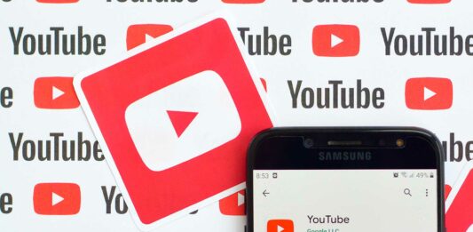 Cómo ganar dinero en YouTube | Guía completa 2020 para generar ingresos con tu canal teléfono sobre fondo con el logo de Youtube mostrado la aplicación de Youtube en la playstore