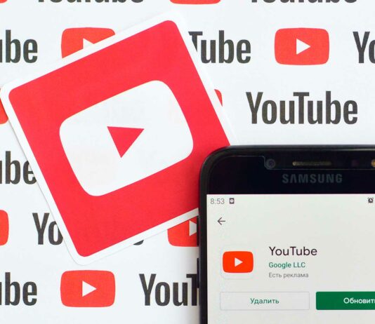 Cómo ganar dinero en YouTube | Guía completa 2020 para generar ingresos con tu canal teléfono sobre fondo con el logo de Youtube mostrado la aplicación de Youtube en la playstore