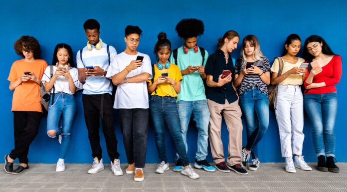 8 Ventajas de los negocios de ocio online Grupo de jóvenes disfrutando de los negocios de ocio online en sus teléfonos móviles