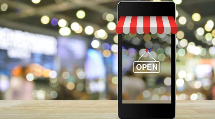 5 ventajas de los negocios online frente a los modelos tradicionales Teléfono móvil sobre una mesa con la imagen de un negocio